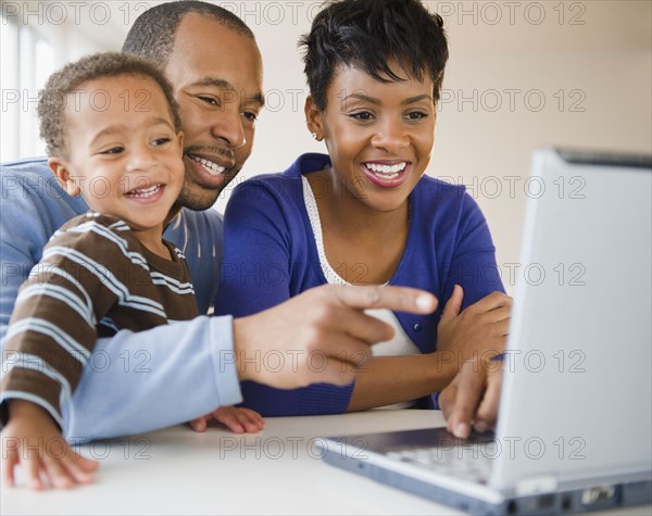 Black family using laptop together