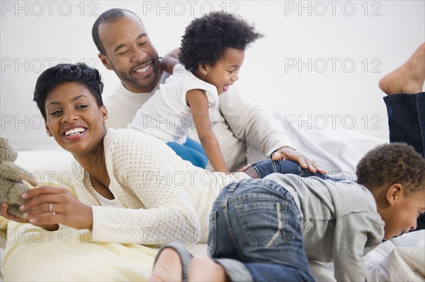 Black family laying on bed together