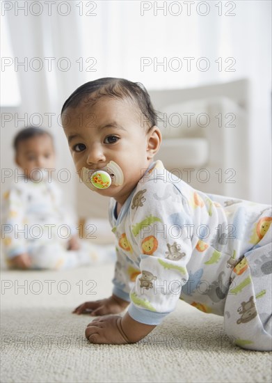 Mixed race baby crawling on floor