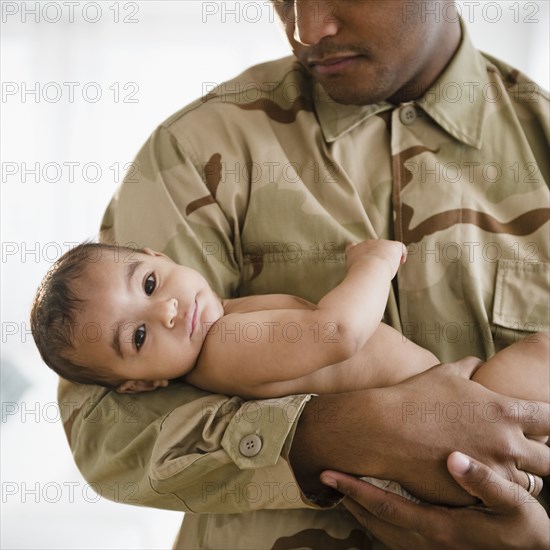 Solder in uniform holding baby boy