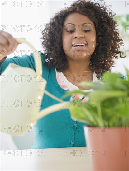 African American woman watering plant