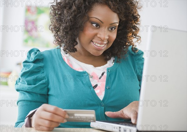 African American woman shopping online with credit card