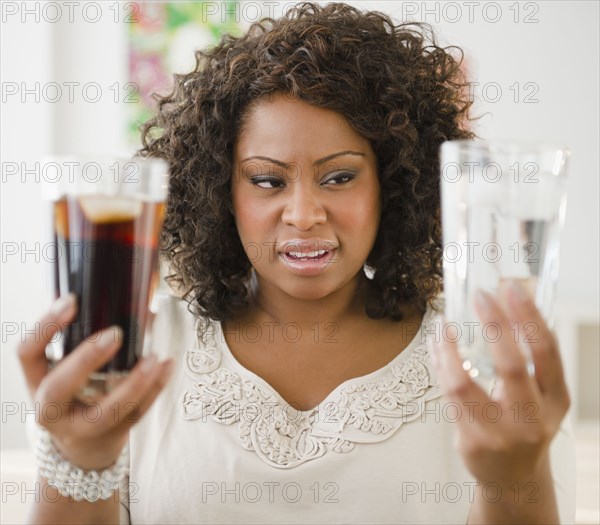 African American woman looking at water and soda