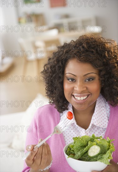 African American woman eating salad