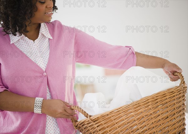 African American woman carrying laundry basket