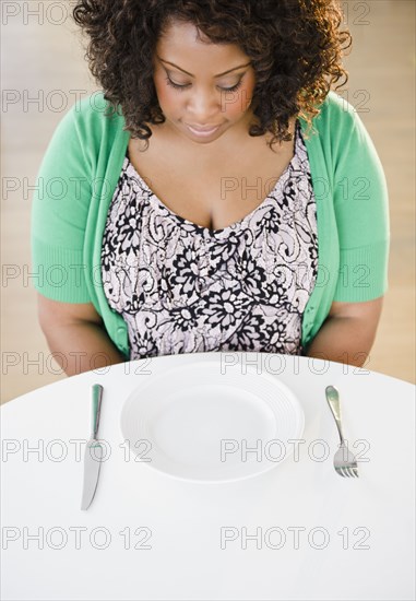 African American woman looking at empty plate