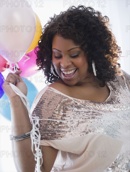 African American woman holding balloons