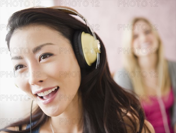 Asian woman listening to headphones