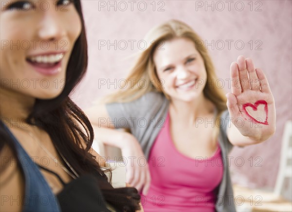 Caucasian woman with heart drawn on her hand