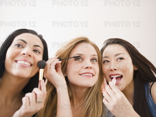 Friends putting makeup on together