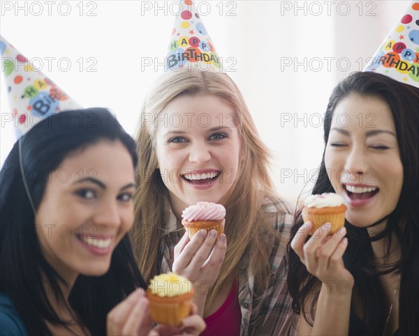 Friends eating cupcakes at birthday party