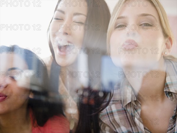 Friends kissing glass