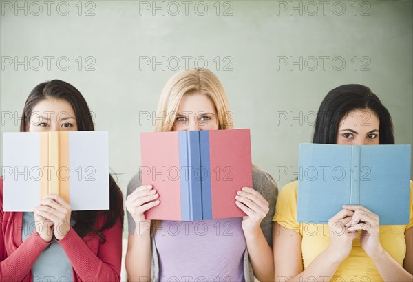 Women hiding behind books