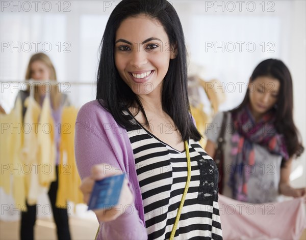 Hispanic woman handing over credit card in store