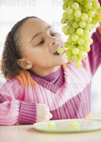African American girl eating grapes