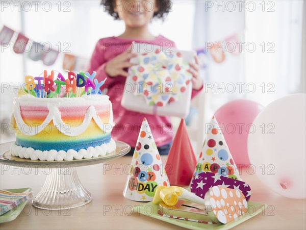 African American girl holding gift at birthday party