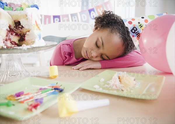 African American girl sleeping at birthday party