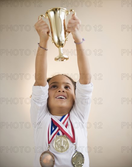 African American girl holding up trophy
