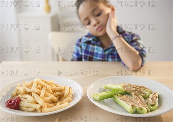African American girl looking at healthy and unhealthy food