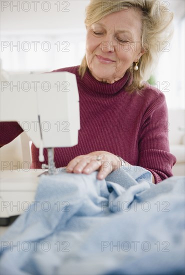 Caucasian woman using sewing machine