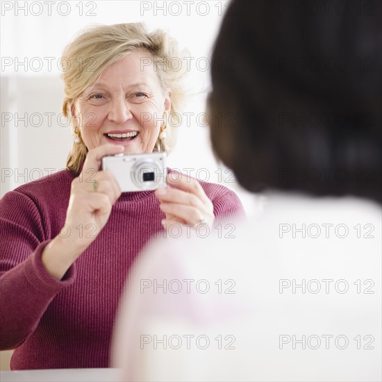 Caucasian woman taking photograph of friend