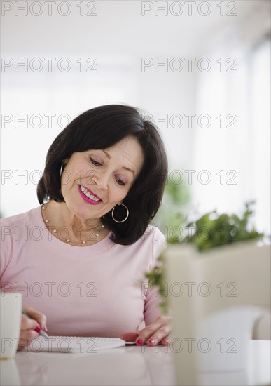 Mixed race woman writing in journal