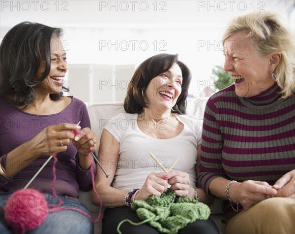 Friends laughing and knitting together