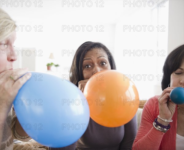 Friends blowing up balloons together