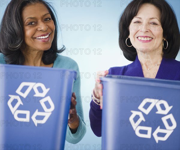 Friends carrying recycling bins