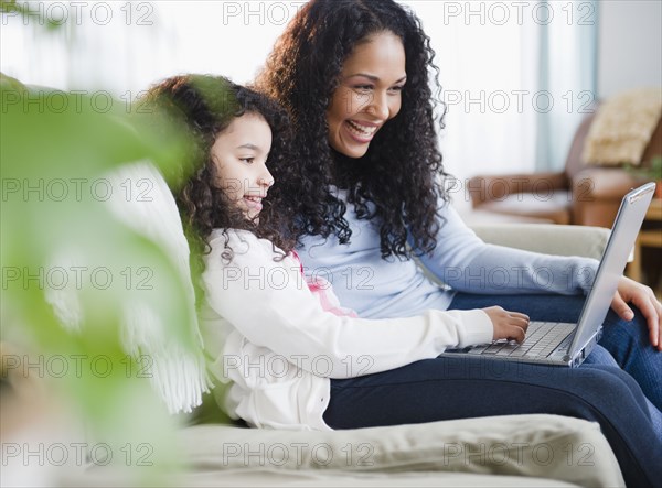 Mother and daughter using laptop together