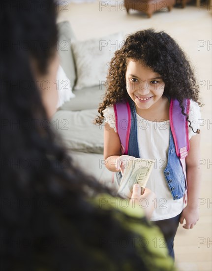 Mother handing money to daughter