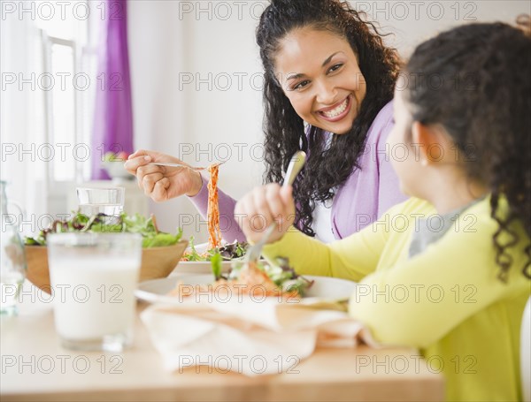 Mother and daughter eating dinner together