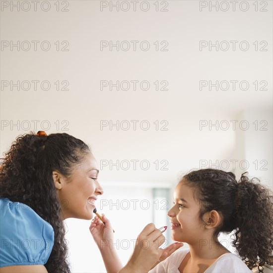 Mother and daughter putting on makeup