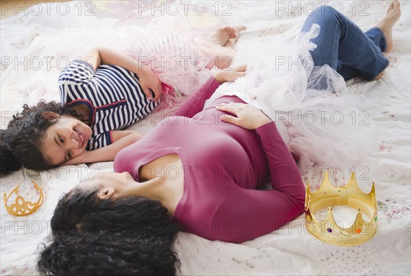 Mother and daughter in costumes laying on floor