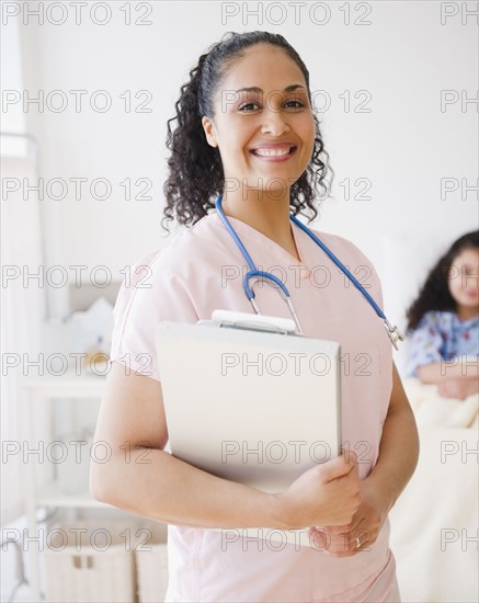 Smiling mixed race nurse in hospital room