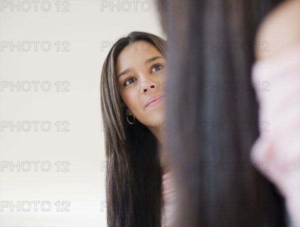 Hispanic teenager looking into mirror