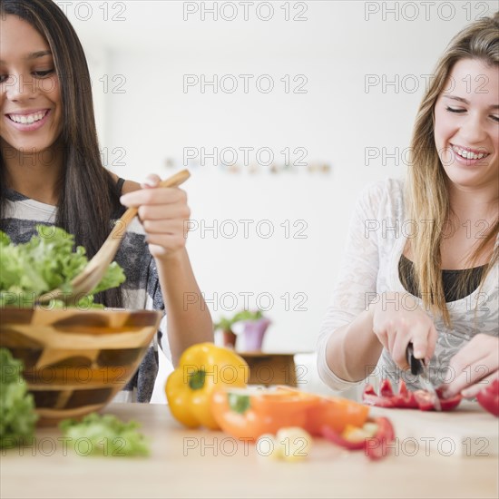 Teenage girls preparing salad together