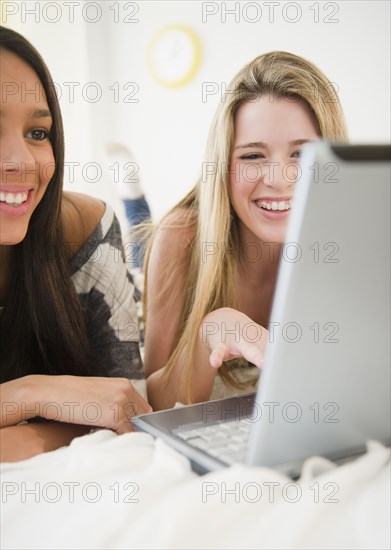 Teenage girls looking at laptop together