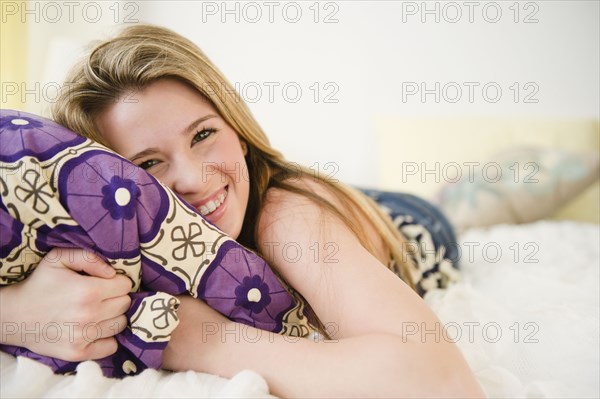 Caucasian teenage girl laying on bed