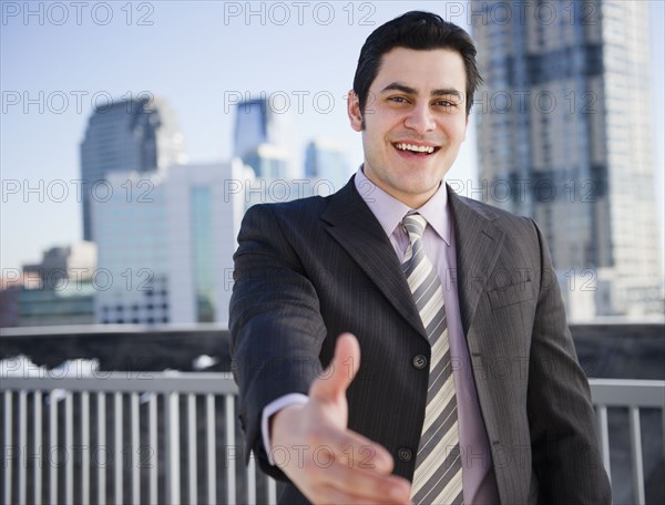 Hispanic businessman with hand outstretched