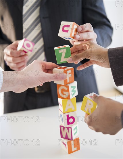 Business people stacking alphabet blocks