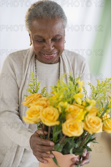 Black woman arranging roses in vase