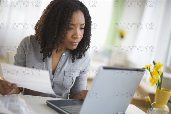 Mixed race woman paying bills online