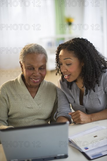Daughter using laptop with mother
