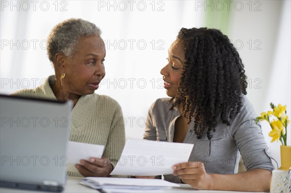 Daughter helping mother pay bills online