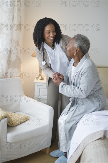 Nurse helping woman get out of bed