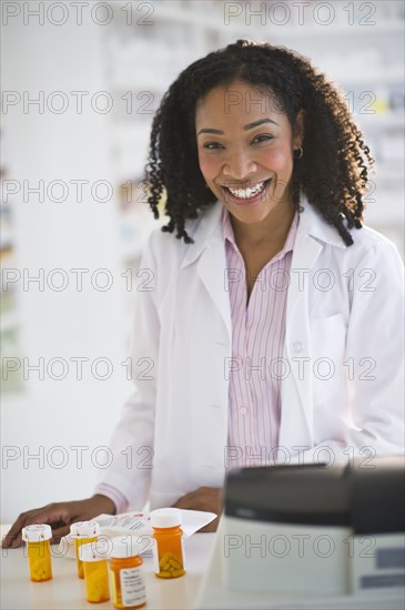 Smiling pharmacist working with medication