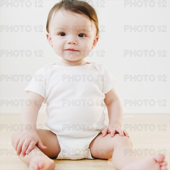 Mixed race baby sitting on floor