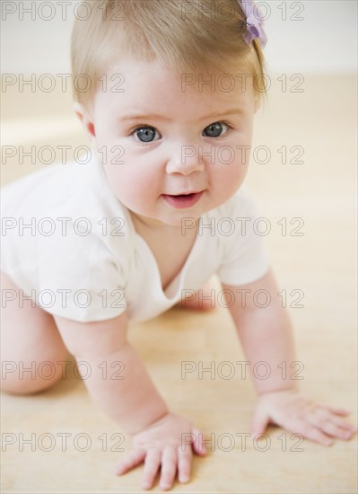 Caucasian baby crawling on floor