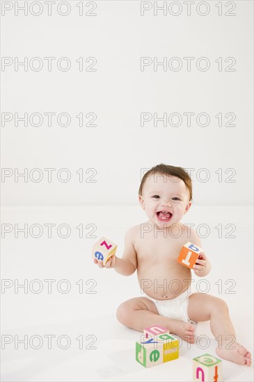 Mixed race baby playing with alphabet blocks